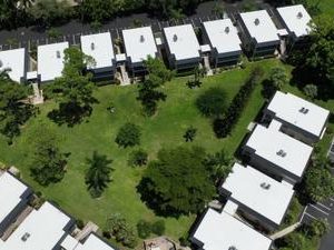 Aerial view of finished white flat roofs across a villa community