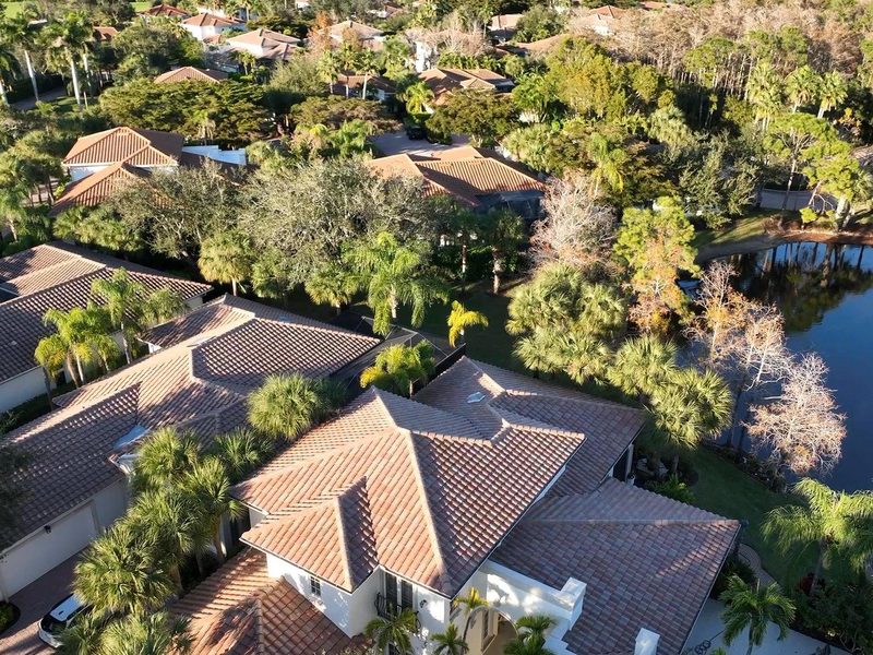 Aerial view of finished tile roofs on homes beside a lake