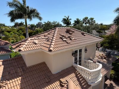 Concrete tile being installed on a large roof, work in progress